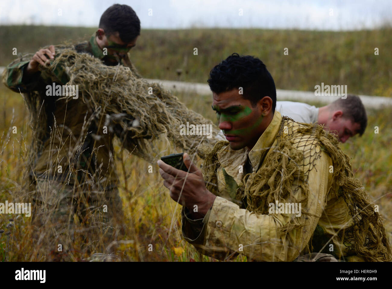 US-Soldaten, das 1. Bataillon, 4. Infanterie-Regiment zugewiesen Gesicht auftragen und passen Sie ihre Ghillie-Anzüge vor der Teilnahme an der stalking Challenge der Europäischen besten Sniper Squad Wettbewerb bei der 7. Armee Training Command, Truppenübungsplatz Grafenwöhr, Bayern, Deutschland, 26. Oktober 2016. Die beste Sniper Squad Europapokal ist ein Army Europe-Wettbewerb herausfordernde Militärs aus in ganz Europa zu konkurrieren und verbessern die Zusammenarbeit mit Verbündeten und Partnerstaaten. (Foto: U.S. Army Spc. Emily Houdershieldt) Europäische beste Sniper Squad Wettbewerb 2016 161026-A-UK263-198 Stockfoto