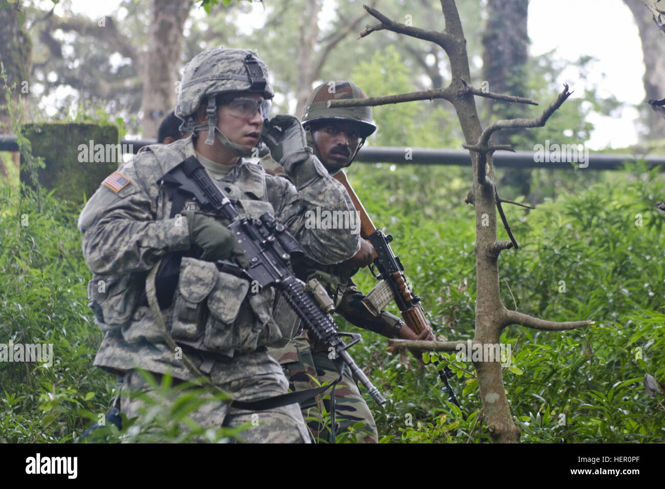 Ein US-Soldat mit 5-20. Infanterie-Regiment, 1-2 Stryker Brigade und seinem indischen Amtskollegen einen improvisierten Sprengkörpern Erkennung Kurs 17. September 2016, im Chaubattia Militärstation, Indien bewegen durch Stockfoto