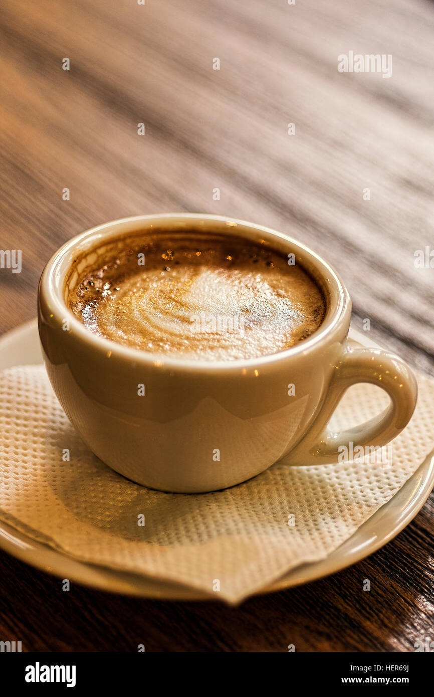 Kaffee-Tasse und Untertasse auf einem Holztisch. Dunklen Hintergrund. Guten Morgen oder Kaffeepause Konzept. Stockfoto