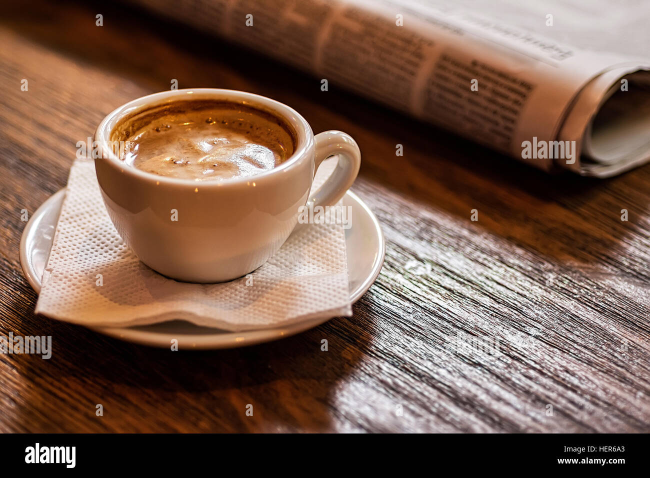 Tasse Kaffee und Zeitung auf einem Holztisch. Guten Morgen oder Kaffeepause Konzept. Stockfoto
