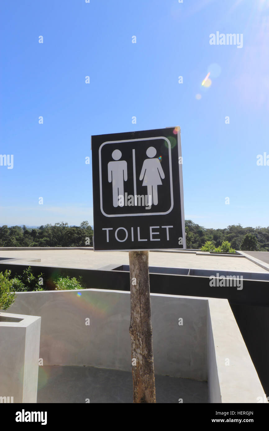 WC-Schild mit Blendenfleck und blauer Himmelshintergrund Stockfoto