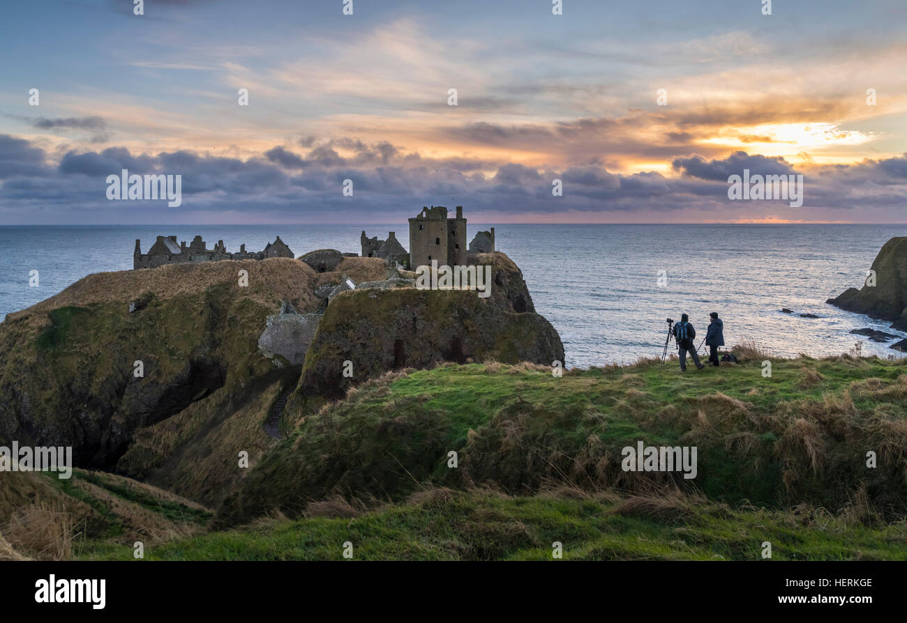 Zwei Fotografen erfassen Sie einen Winter-Sonnenaufgang über Dunnottar Castle, in der Nähe von Stonehaven im Nordosten Schottlands Stockfoto