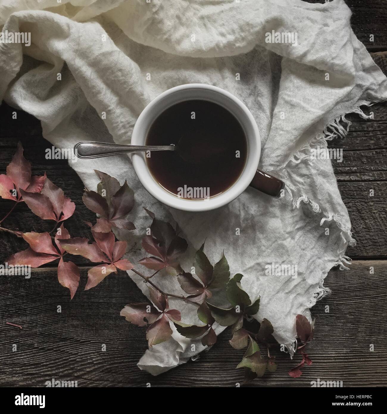 Tasse Kaffee mit Herbstlaub Stockfoto