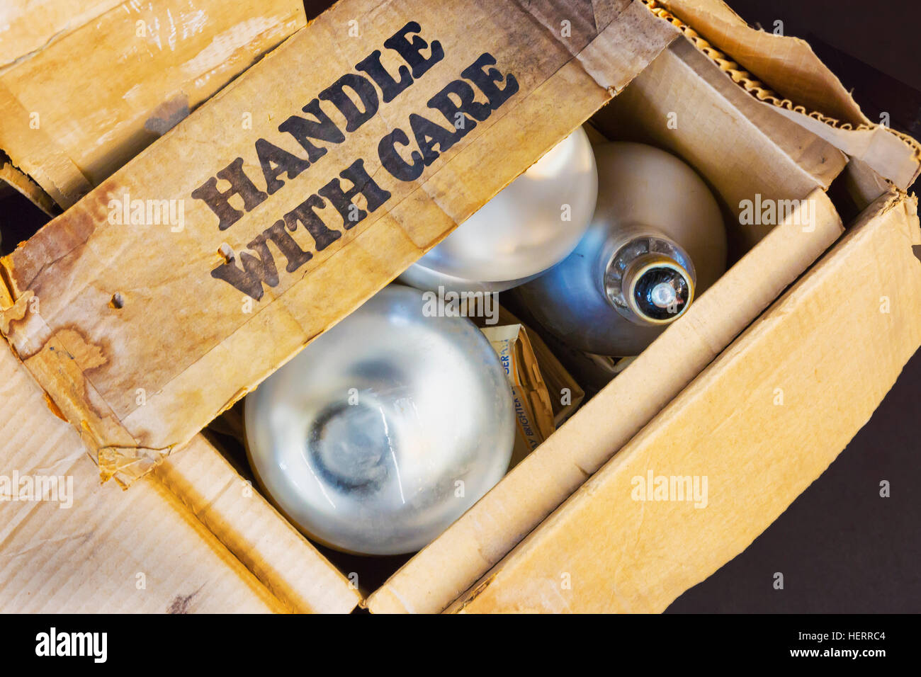 Alten Karton beschriftet "Handle With Care" mit fluoreszierendem Flutlicht. Stockfoto