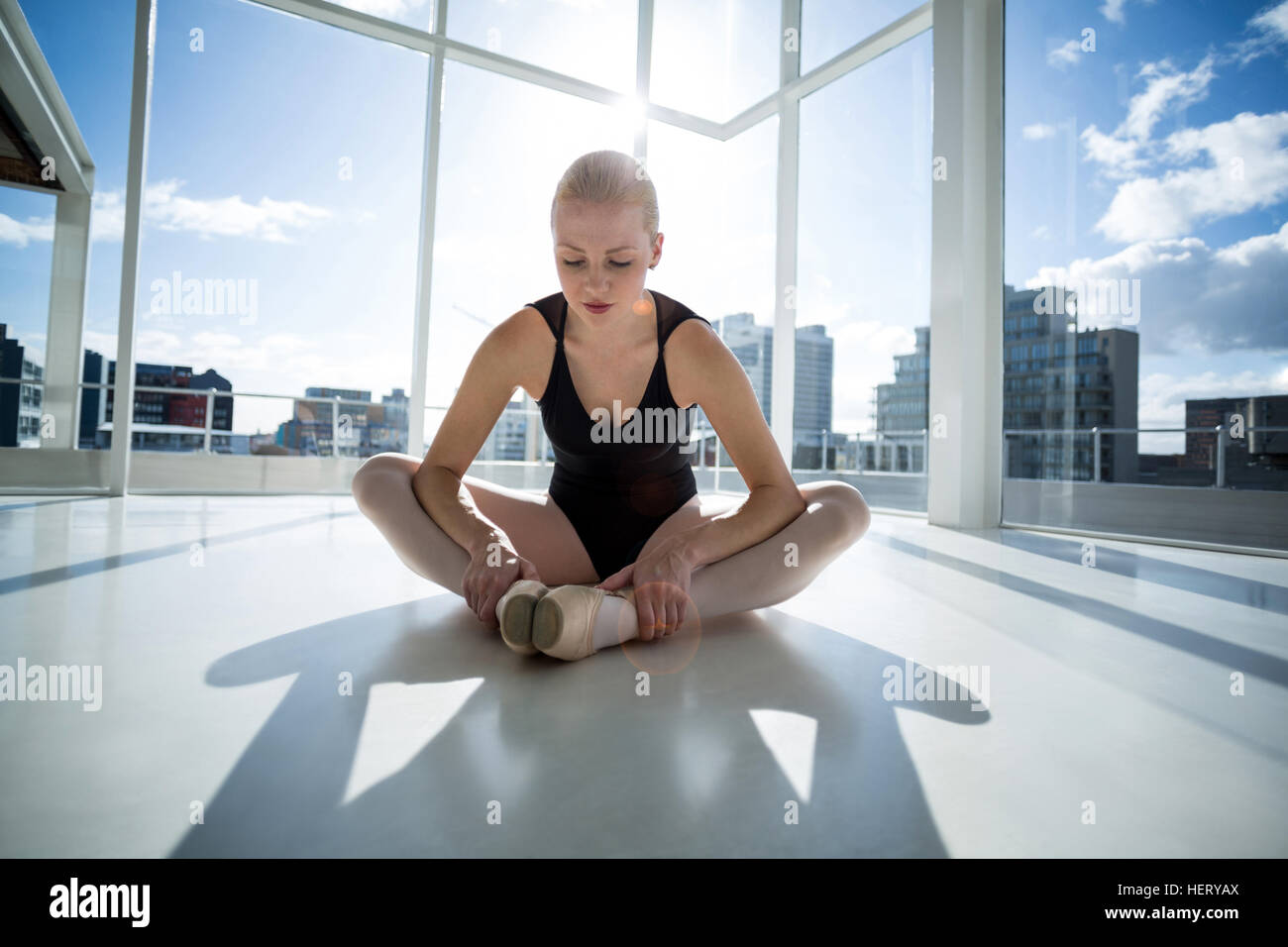 Ballerina, die Durchführung einer stretching Übung im Ballettstudio Stockfoto