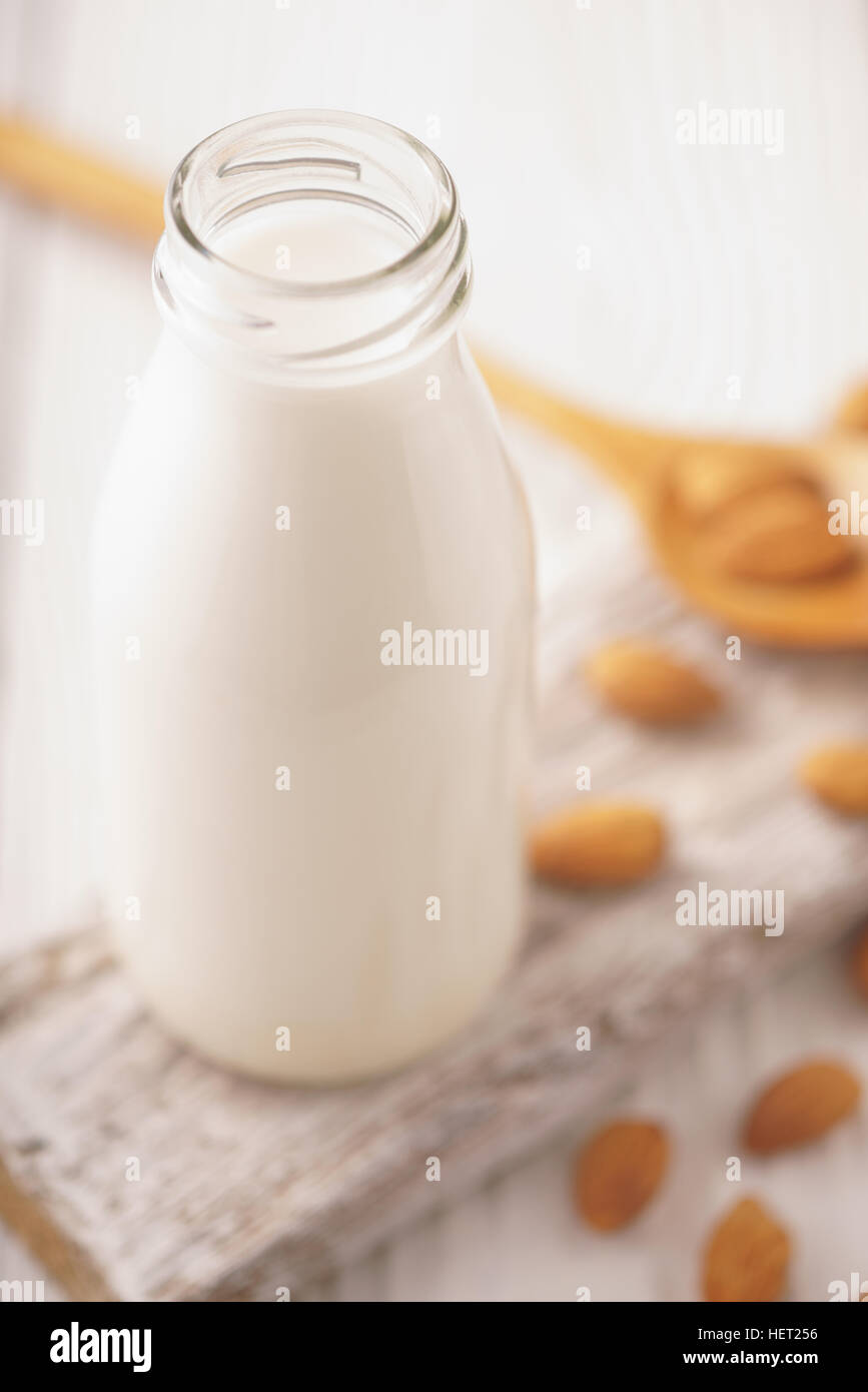 Mandel-Milch in ein Glas Flasche und Mandel Muttern auf einer vertikalen Ständer Stockfoto