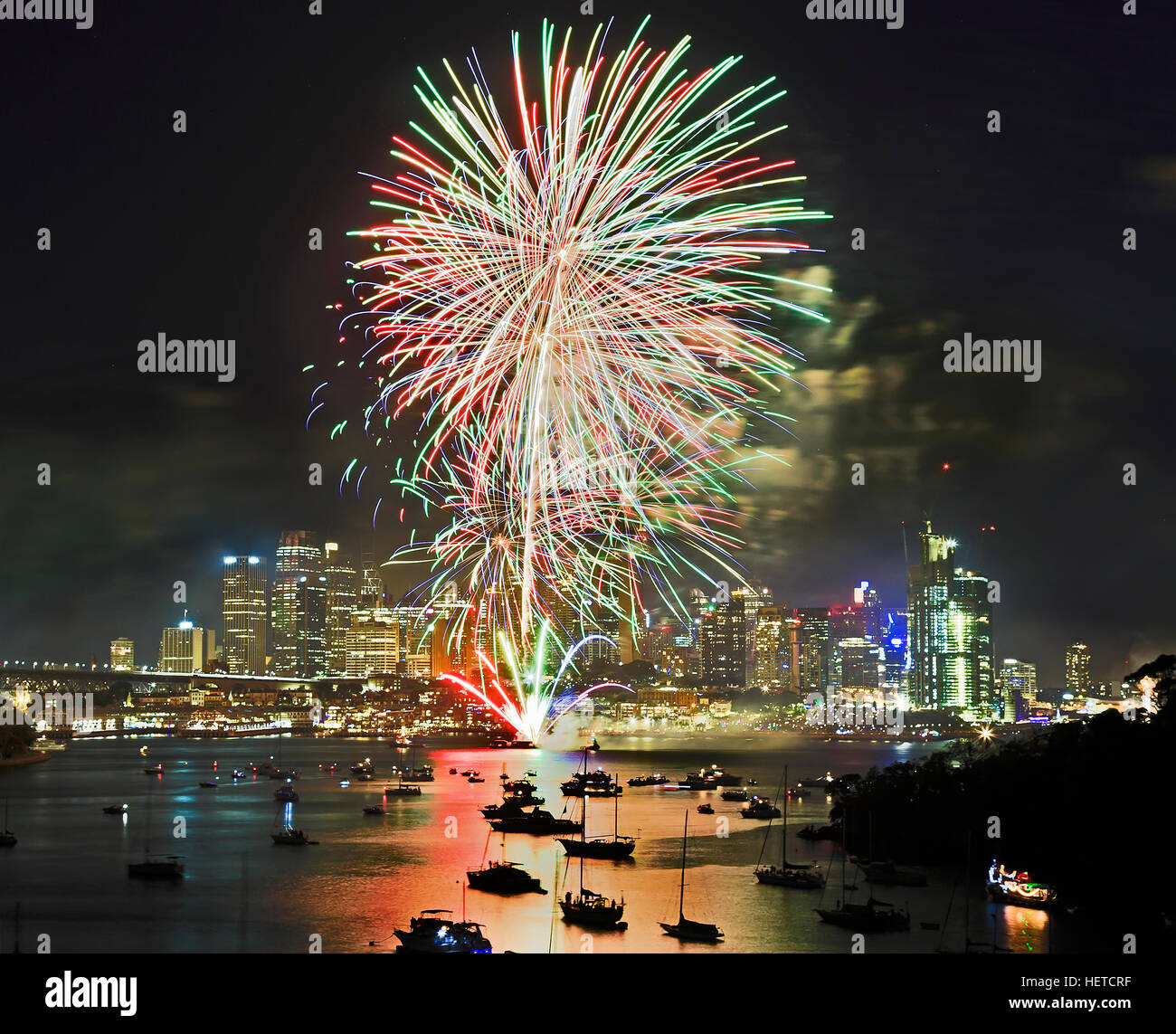 Sydney Silvester Feuerwerk über dem Hafen und Stadt CBD Gewässern mit Masse von Serienfahrzeugen und Yachten. Farbige Lichtkugeln in den Himmel erleuchten Australi Stockfoto