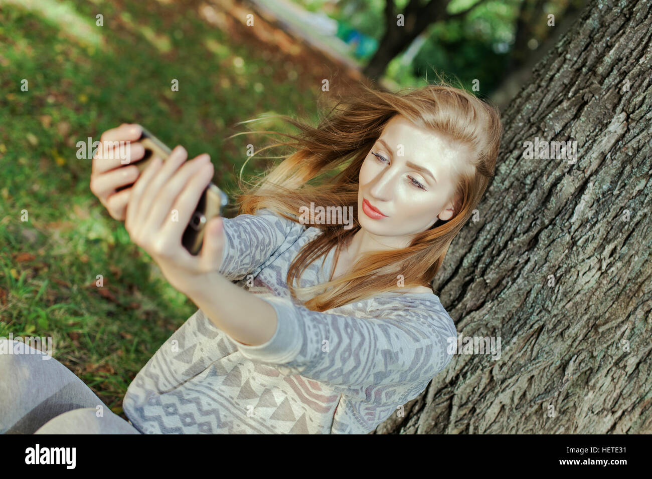 Schöne Mädchen mit blauen Augen macht Selfie im freien Stockfoto