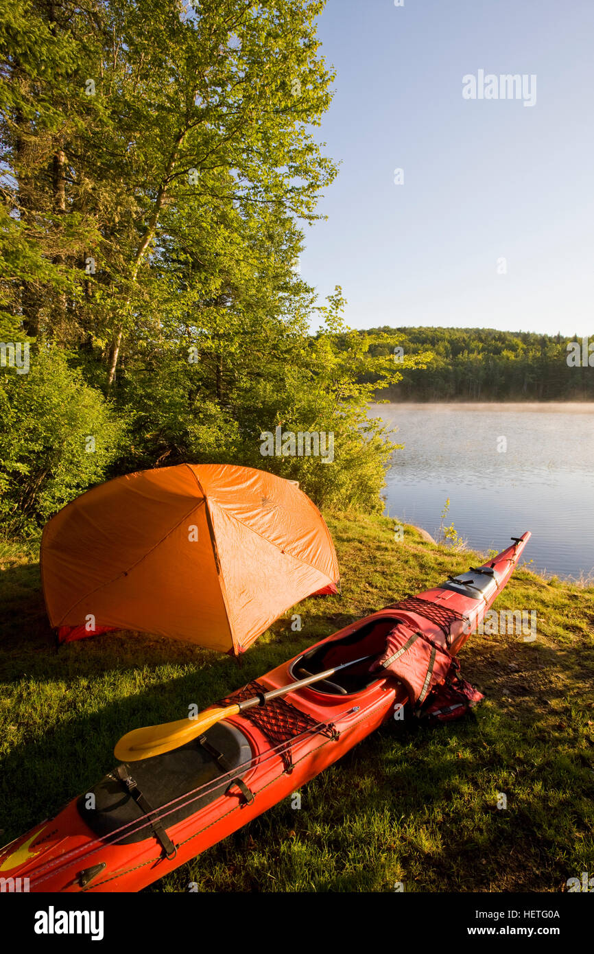 Ein Kajak und ein Zelt neben dem Androscoggin auf einem abgelegenen Campingplatz im Mollidgewock State Park in Errol, New Hampshire. Stockfoto