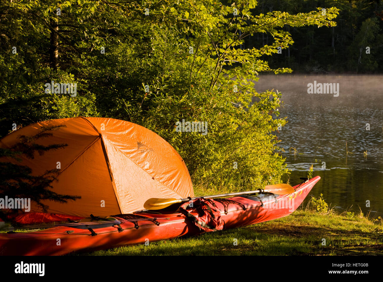 Ein Kajak und ein Zelt neben dem Androscoggin auf einem abgelegenen Campingplatz im Mollidgewock State Park in Errol, New Hampshire. Stockfoto
