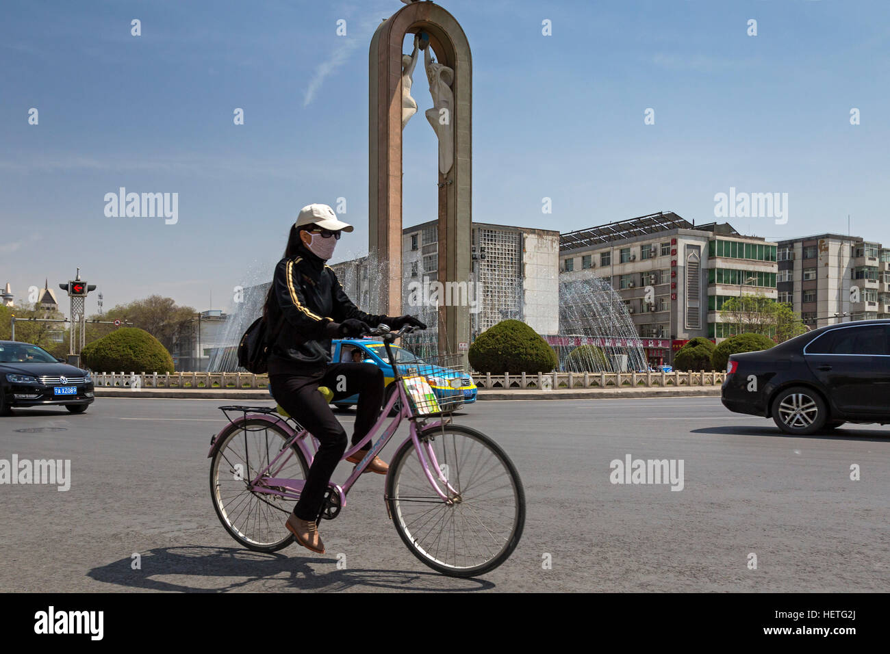 Chinesisches Mädchen mit dem Fahrrad an Kreuzung in Yinchuan, Ningxia, China Stockfoto