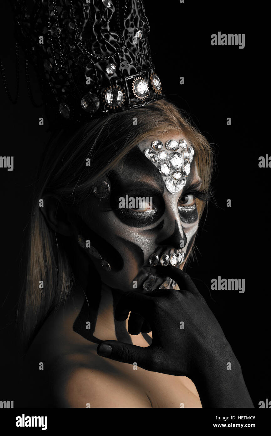 Schwarz / weiß-Tag der Toten schimmernden kreative Make-up in Candy-Schädel-Stil mit silbernen Perlen und gotische Krone Kopfbedeckung Stockfoto