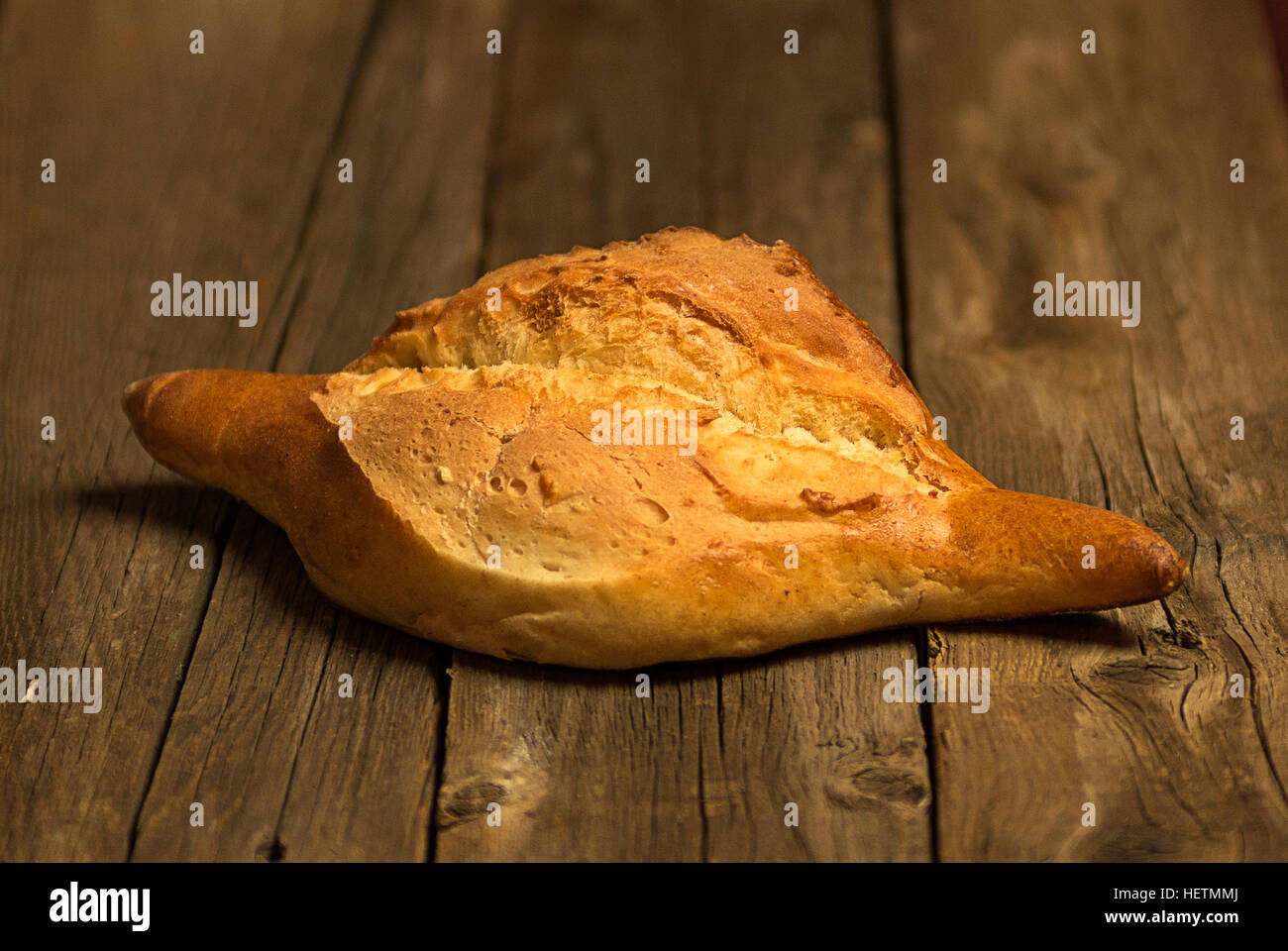 Frisch gebackenes Brot ruht auf einem alten Holztisch Stockfoto