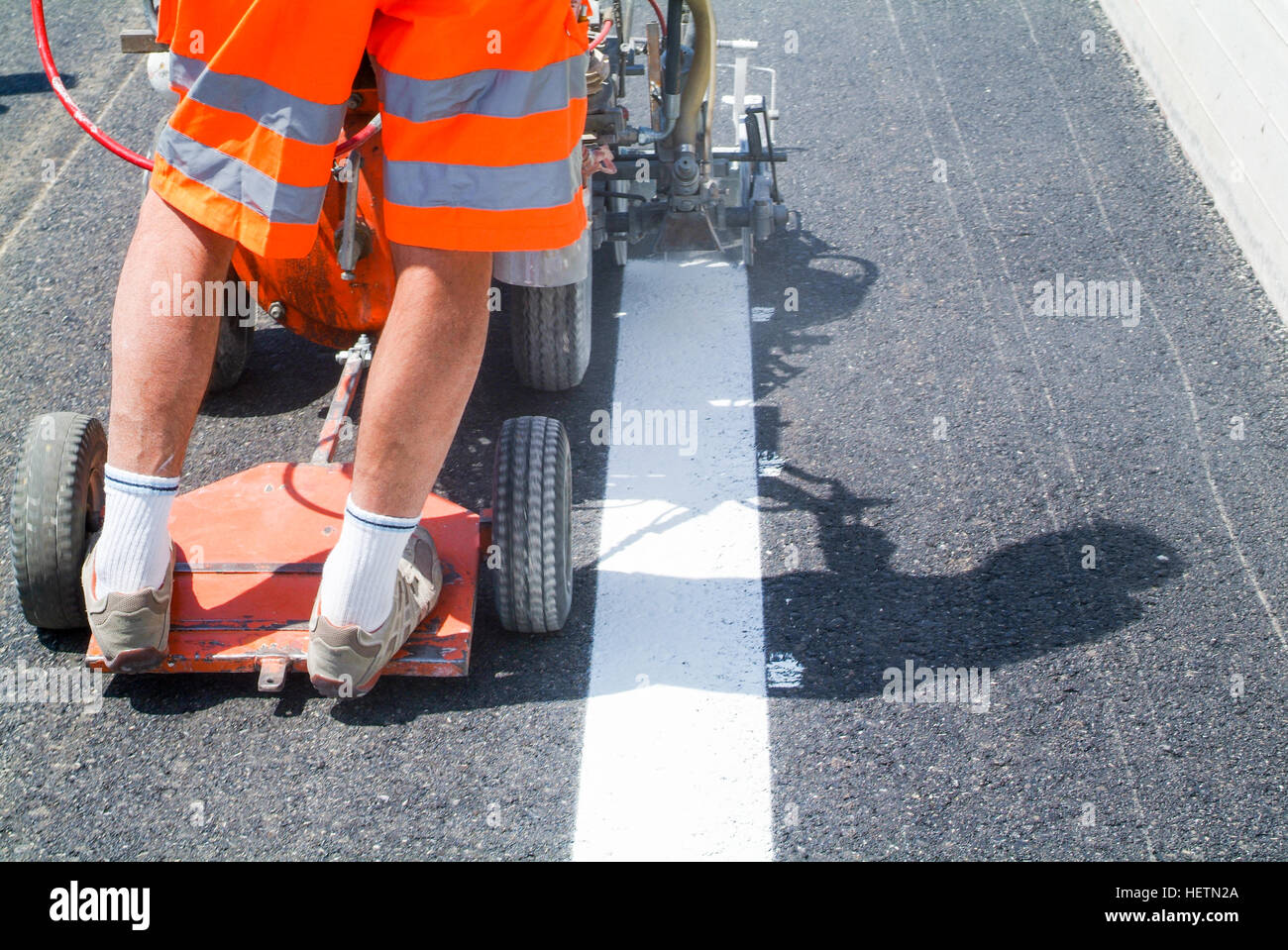 Bissone, Schweiz - 20. Juni 2011: Maschine ausgeworfen und Arbeiter auf der Straße und Verkehr melden Malerei Stockfoto