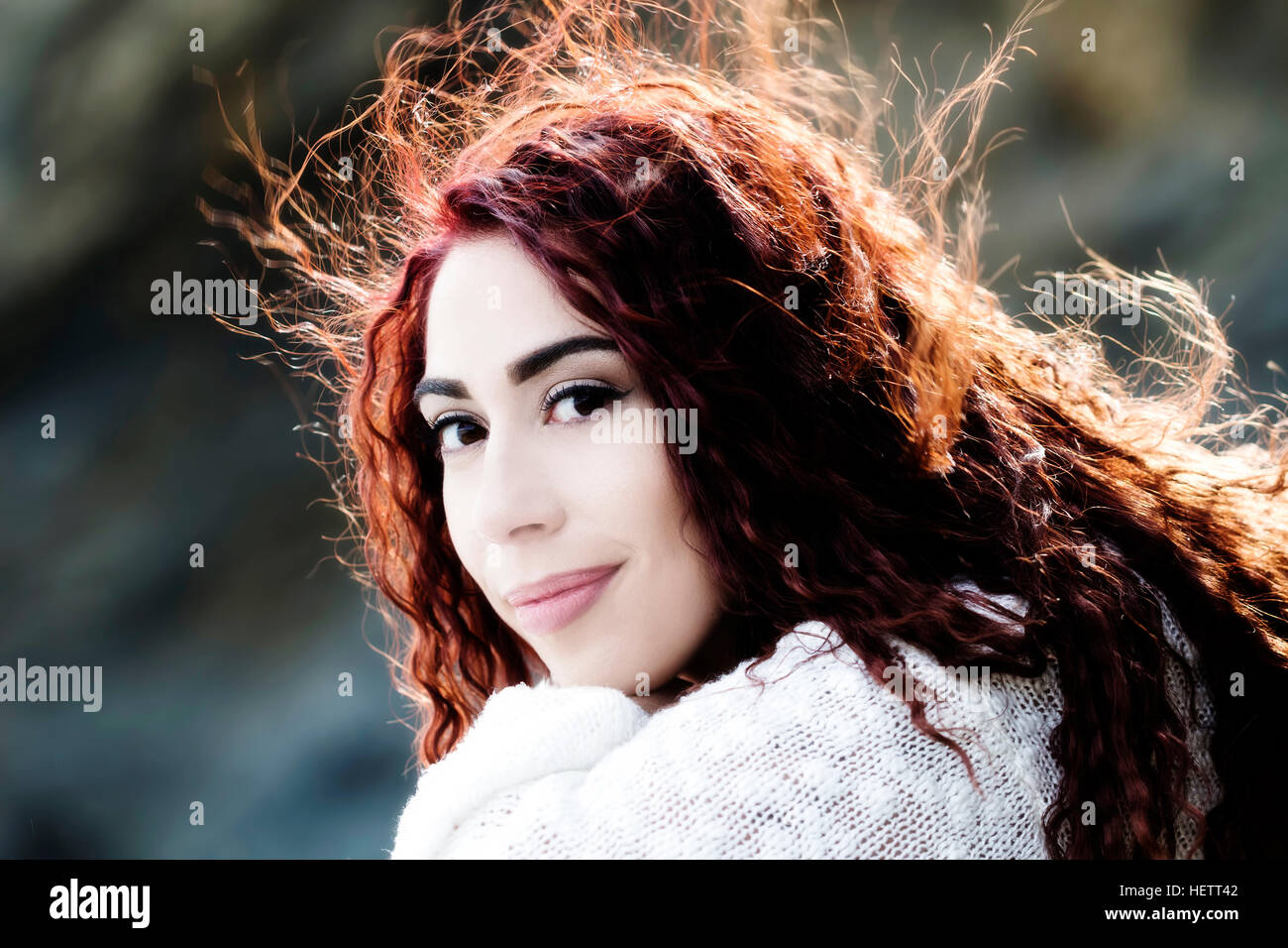 Hispanic Frau Outdoor Portrait weiß stricken Top und Haare im Wind wehen Stockfoto