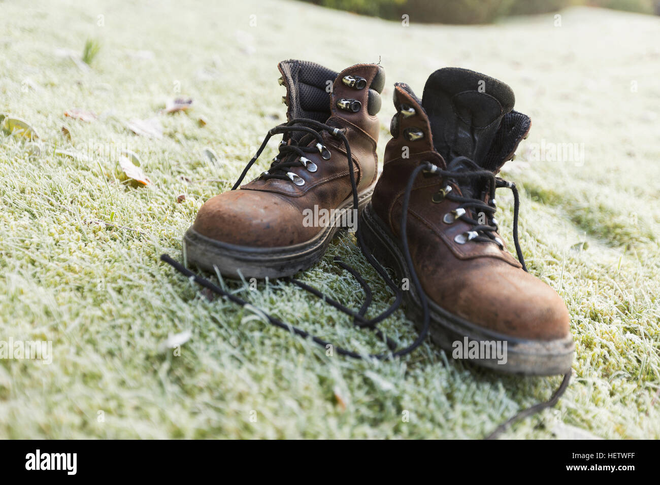 Paar braune preloved schäbig Wanderschuhe auf dem frostigen grünen Rasen Stockfoto