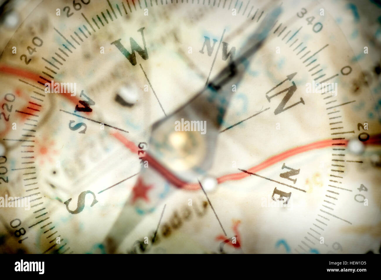 Detail eines magnetischen Kompasses auf dem Hintergrund der das unscharfe Bild der geographischen Karte Stockfoto