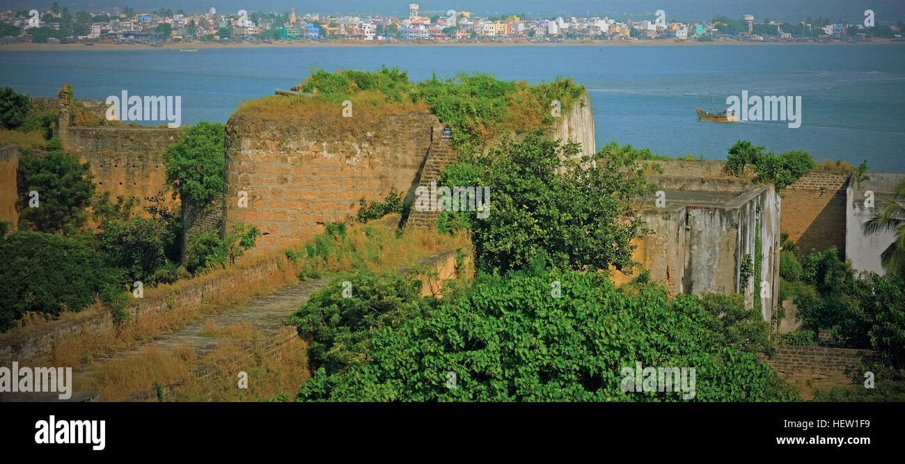 Ruinen des Forts bei Diu Insel mit Blick auf das Arabische Meer und bunte Gehäuse auf der Küste von Gujarat, Indien Stockfoto