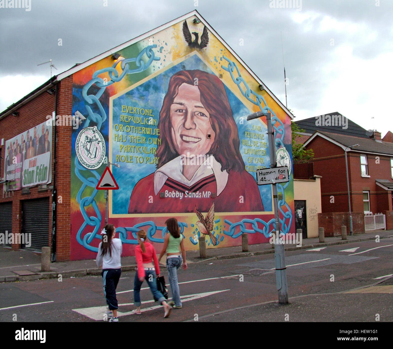 Belfast Falls Rd republikanischen Wandbild - Bobby Sands MP & Sinn Féin Office - mit Kindern, die Straße überqueren Stockfoto
