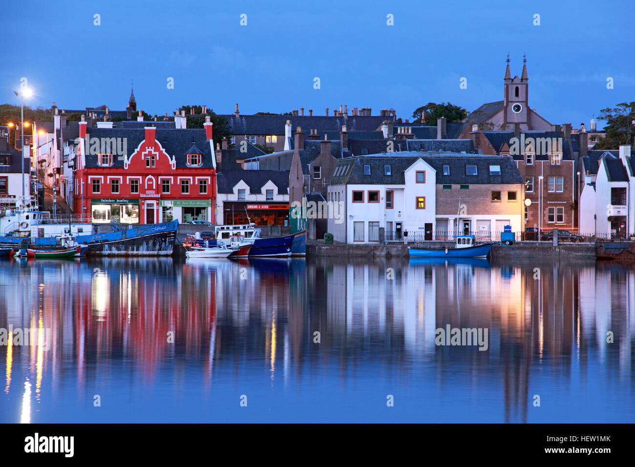 Stornoway, Hauptstadt der Isle of Lewis, historischer Hafen mit Booten, Fischereifahrzeugen und Hütten in der Dämmerung Stockfoto