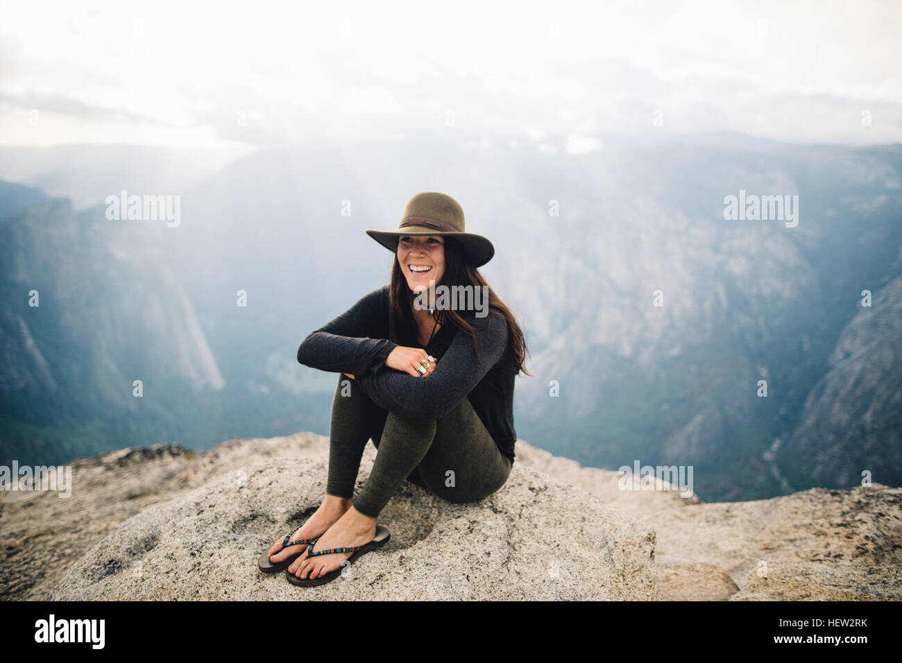 Porträt der jungen Frau am Gipfel des Berges, sitzen mit Blick auf Yosemite Nationalpark, Kalifornien, USA Stockfoto