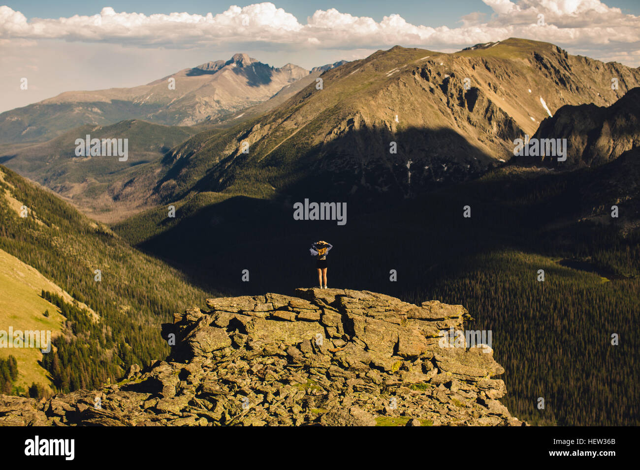 Rückansicht der Frau auf Felsvorsprung wegsehen, Rocky Mountain Nationalpark, Colorado, USA Stockfoto