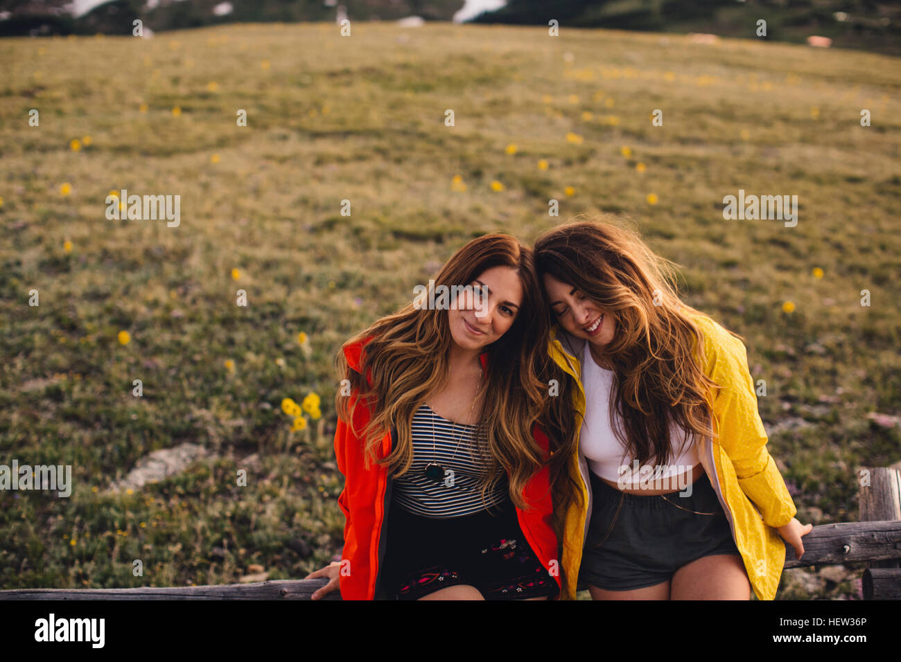 Freunde sitzen nebeneinander Blick in die Kamera Lächeln, Rocky Mountain Nationalpark, Colorado, USA Stockfoto