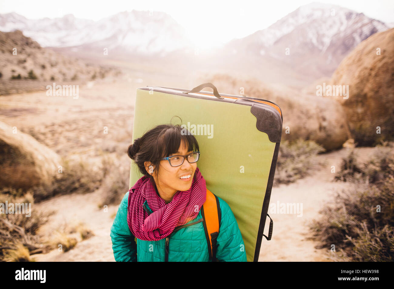 Frau mit Bouldern Matte wegsehen lächelnd, Buttermilch Felsbrocken, Bischof, Kalifornien, USA Stockfoto