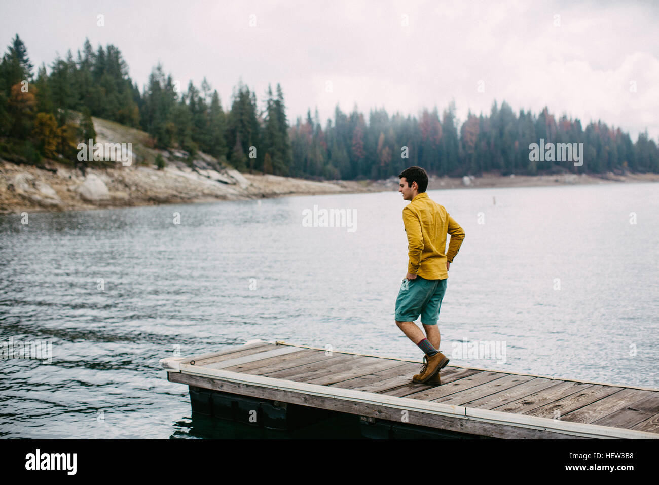 Junger Mann zu Fuß auf Pier in Shaver Lake, Kalifornien, USA Stockfoto