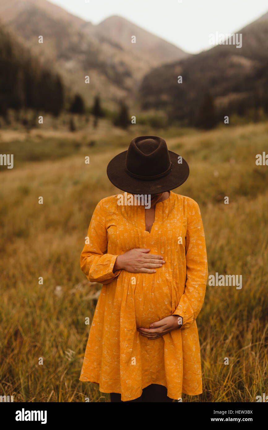 Schwangere Frau, die in ländlicher Umgebung, halten Magen, Mineral King, Sequoia Nationalpark, Kalifornien, USA Stockfoto