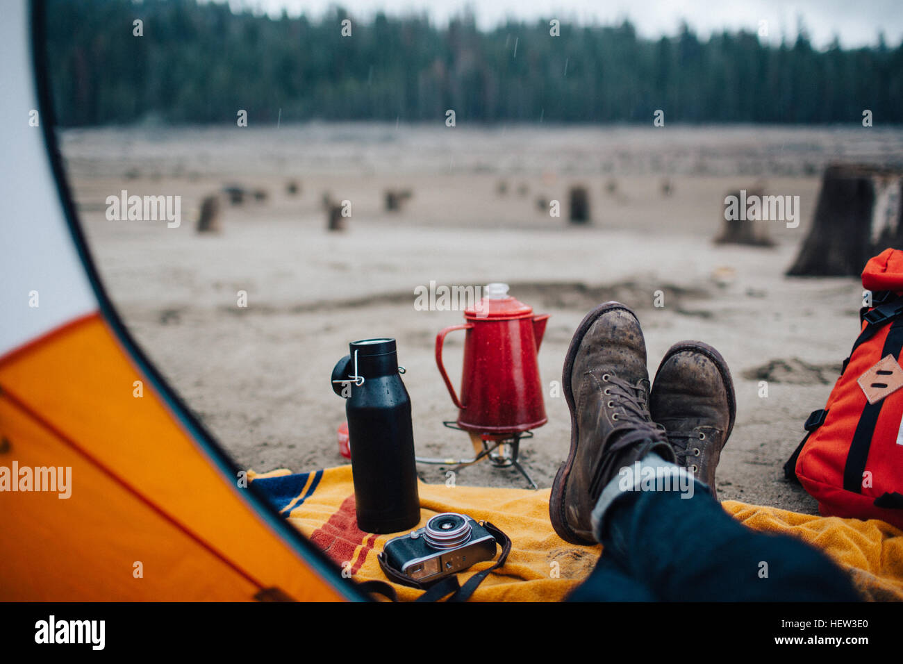 Junger Mann sitzt im Zelt am Strand, Huntington Lake, Kalifornien, USA Stockfoto