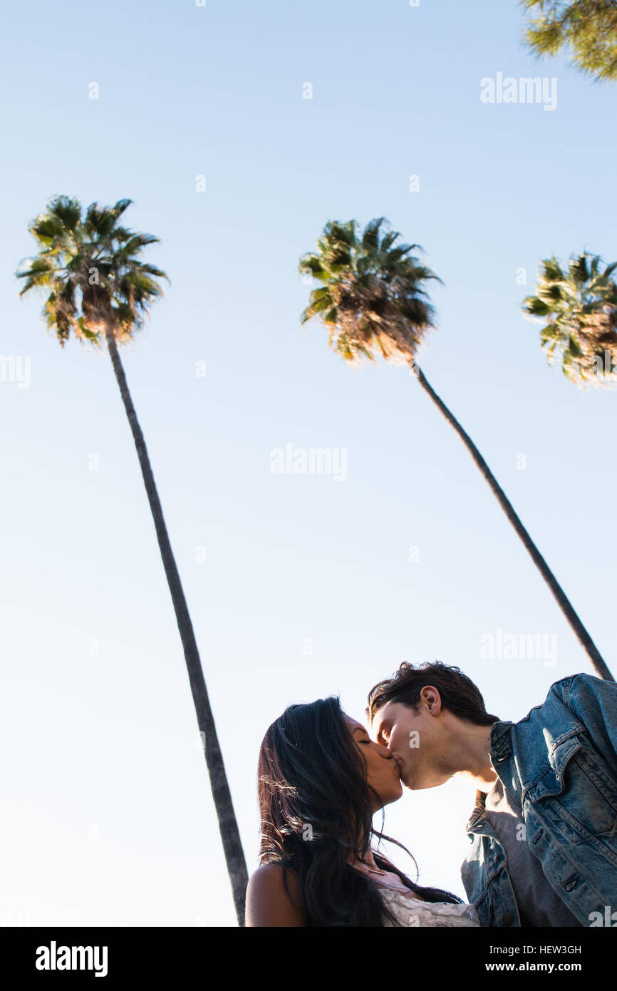Junges Paar walking im Freien, niedrigen küssen, Winkel Ansicht Stockfoto
