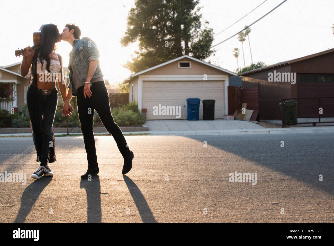 Junges Paar im Freien, küssen, junge Frau Holding Gitarre Stockfoto