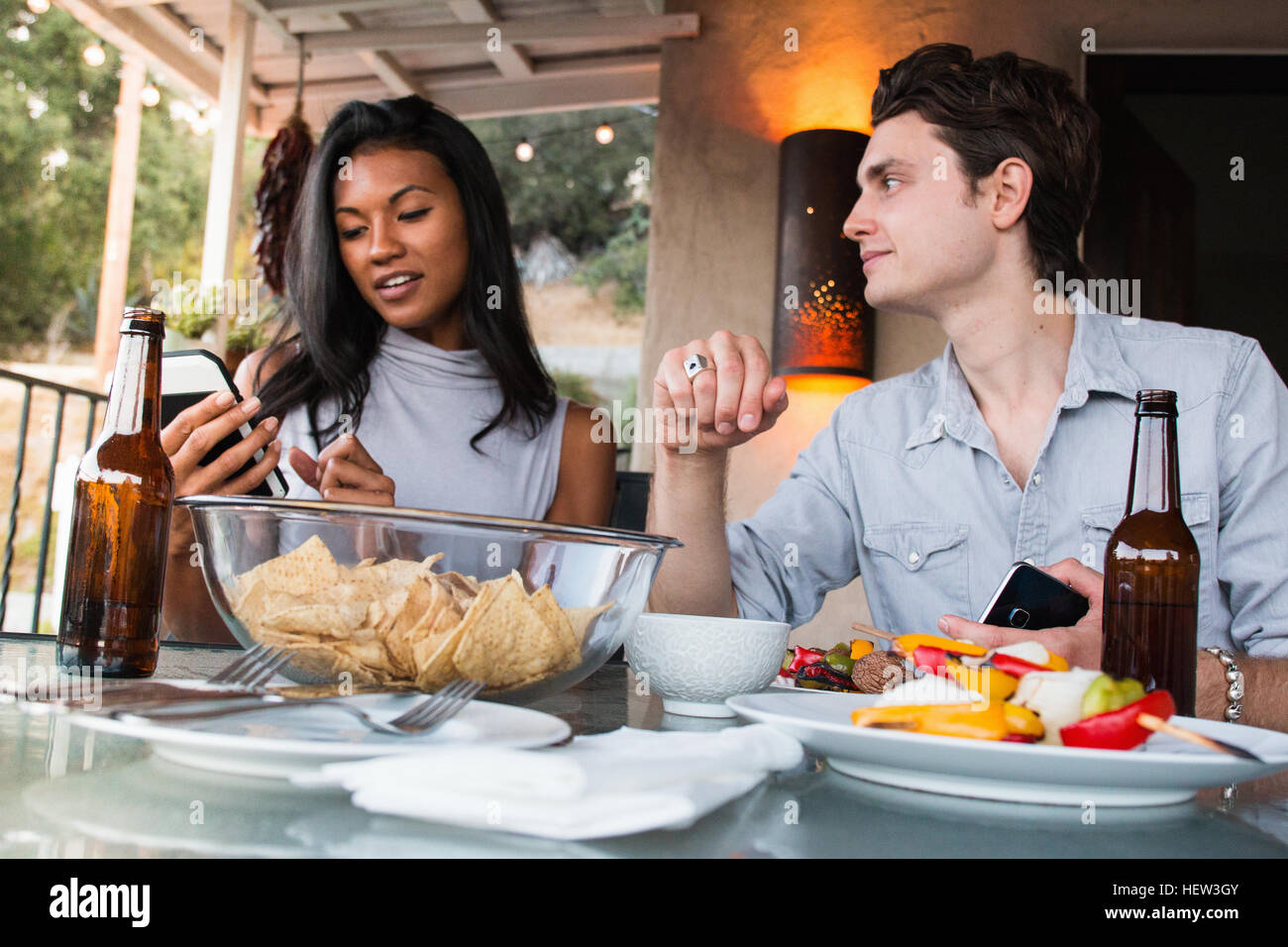 Junges Paar sitzt auf der Veranda, Essen Stockfoto
