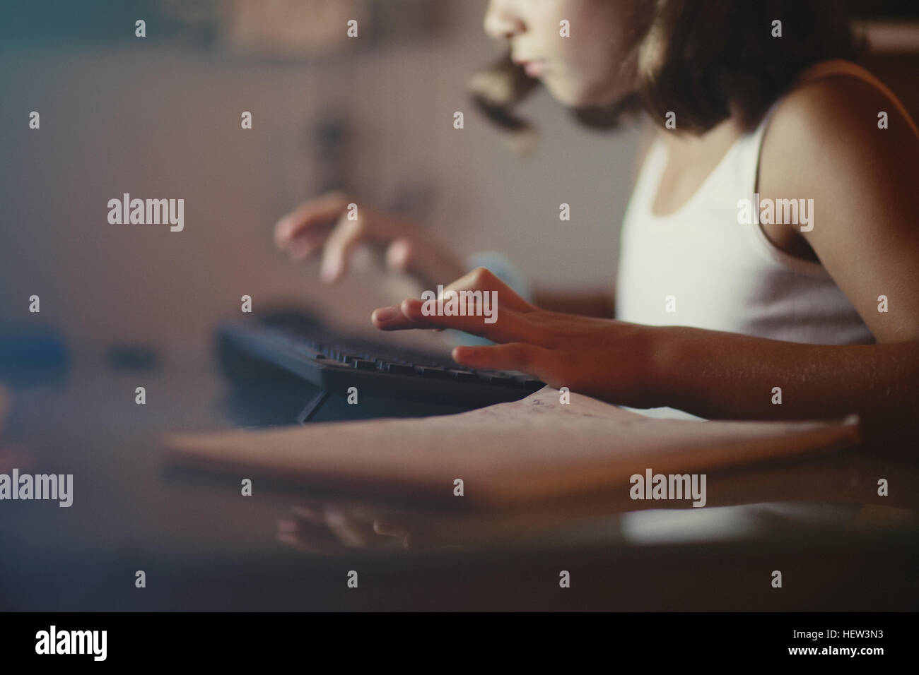 Mädchen mit Computer in schwach beleuchteten Raum Stockfoto