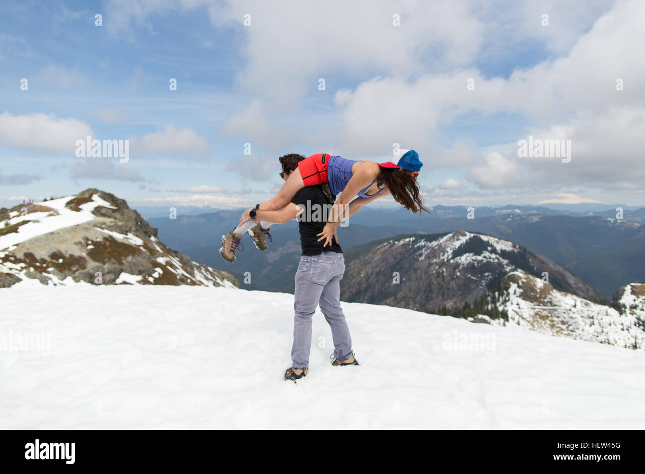 Mann trägt Frau über die Schulter auf Berggipfel, Silver Star Mountain, Washington, USA Stockfoto