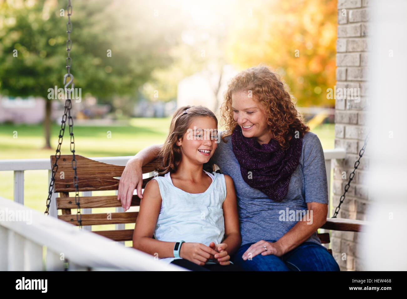 Tante und Nichte auf Veranda Schaukel, Lächeln Stockfoto