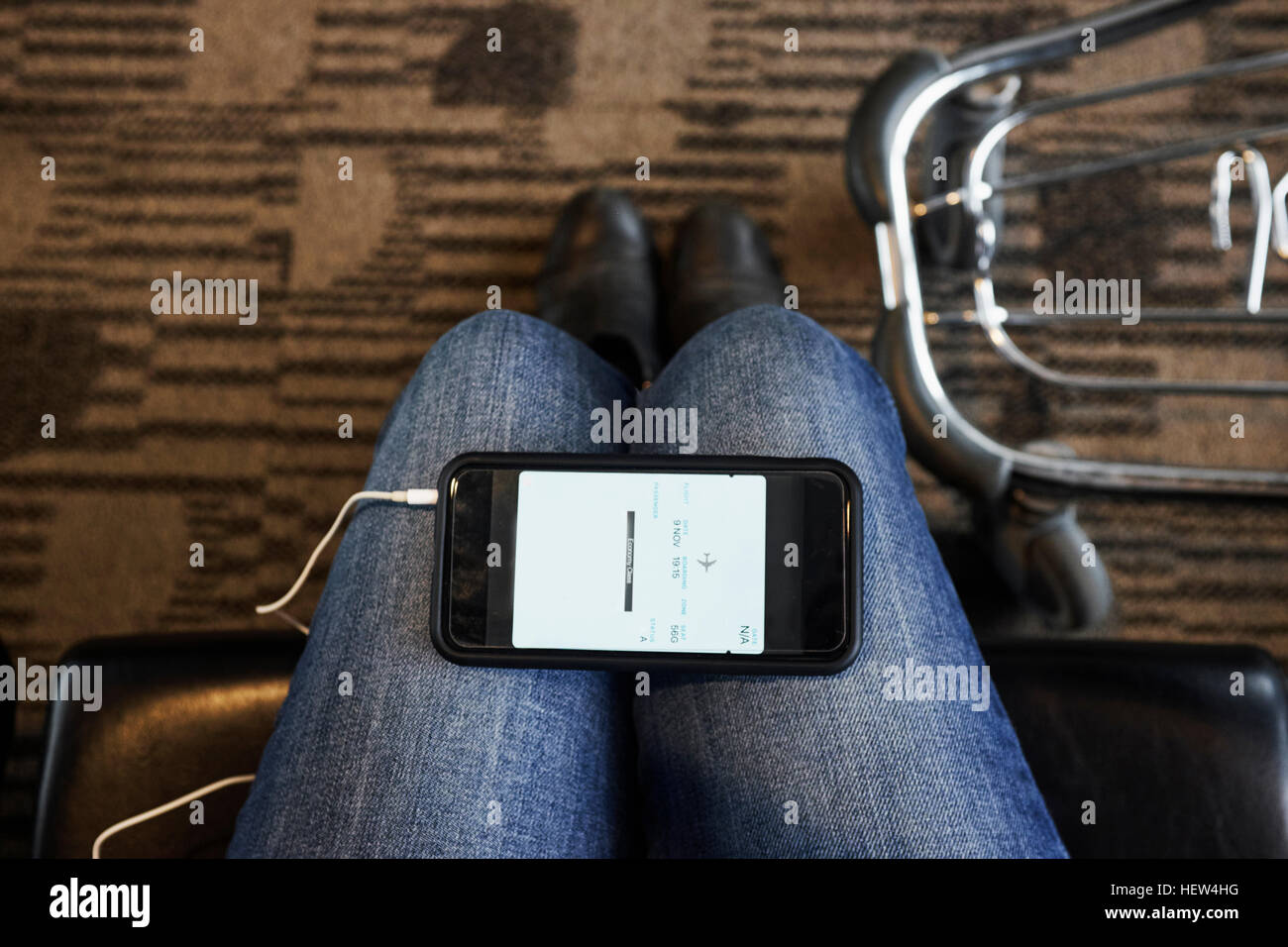 Persönlichen Sicht des Smartphone auf Frau Knien im Flughafen-lounge Stockfoto