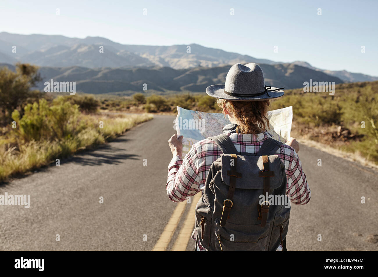 Frau stehend in Wüstenstraße, Blick in die Karte, Sedona, Arizona, USA Stockfoto