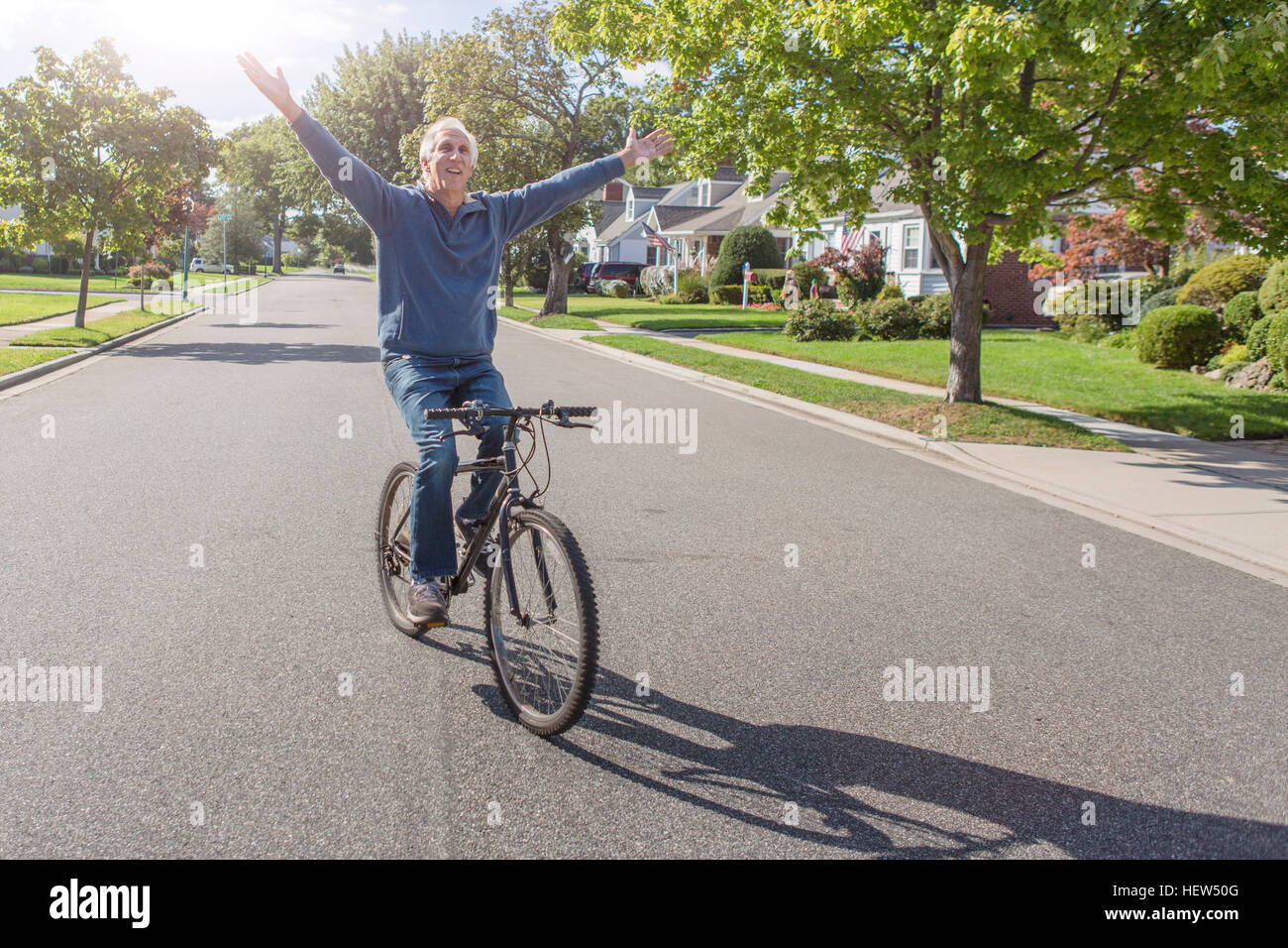 Ältere Mann mit Handzeichen während Radfahren Vorstadt Landstraße Stockfoto