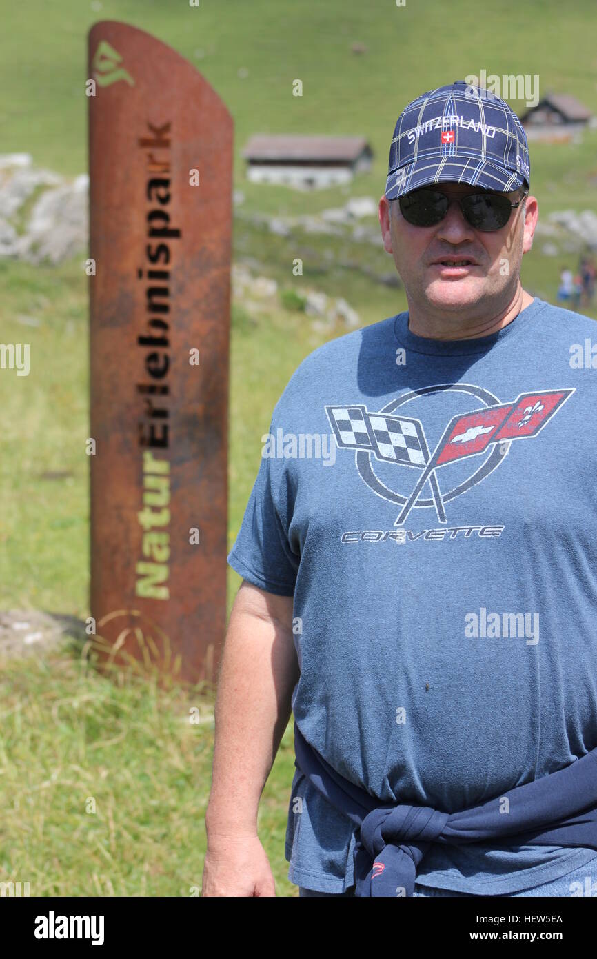 Ein amerikanischer Tourist steht in der Nähe ein Zeichen identifizieren NaturErlebnispark (Natur Discovery Park) in der Nähe der Schweiz Säntis in den Schweizer Alpen. Stockfoto