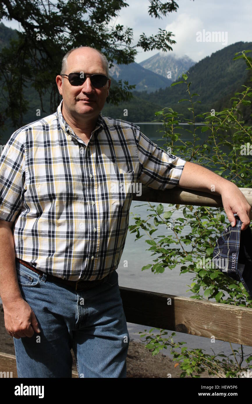 Ein Mann posiert für ein Foto am Alpsee, einem bayerischen See in der Nähe von Hohenschwangau. Stockfoto