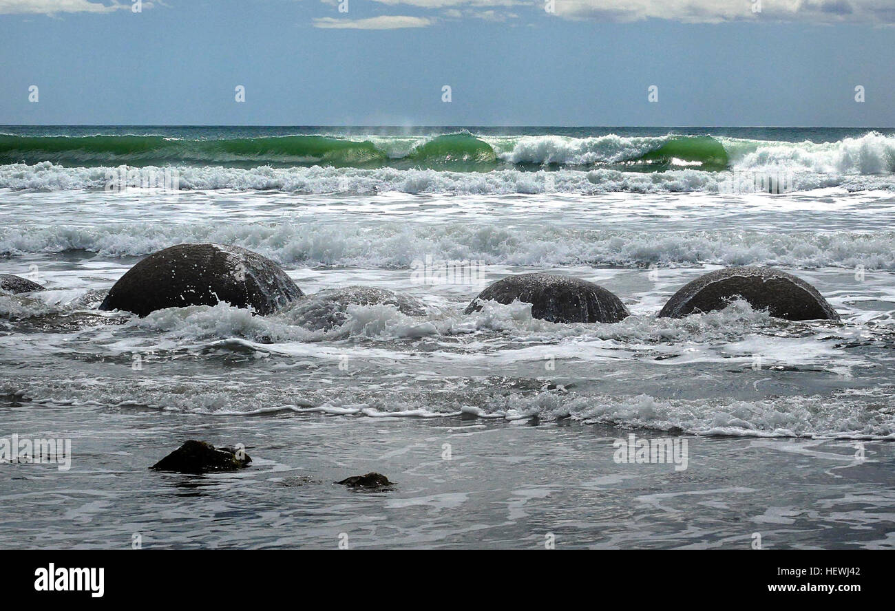 MOERAKI BOULDERS die Moeraki Boulders befinden sich auf Koekohe Strand an einem Ort namens Kumara, auf halbem Weg zwischen Hampden und Moeraki Townships in North Otago. Zugang zu ihnen wird durch eine One-Way-klein-Straße, 1 Meile nördlich entlang der Hauptstraße vom Bahnhof Hillgrove gewonnen. Die Findlinge sind grau gefärbten septarian Konkretionen, die heraus ausgehöhlt durch Wellenschlag von den Klippen von weichen, schwarzen Tonstein, die den Strand zurück. Stellenweise können teilweise freigelegten Konkretionen in den Klippen gesehen werden. Sie bildeten ursprünglich auf dem Meeresboden bei den Tonstein wurde während der frühen Tertiär ansammeln Stockfoto