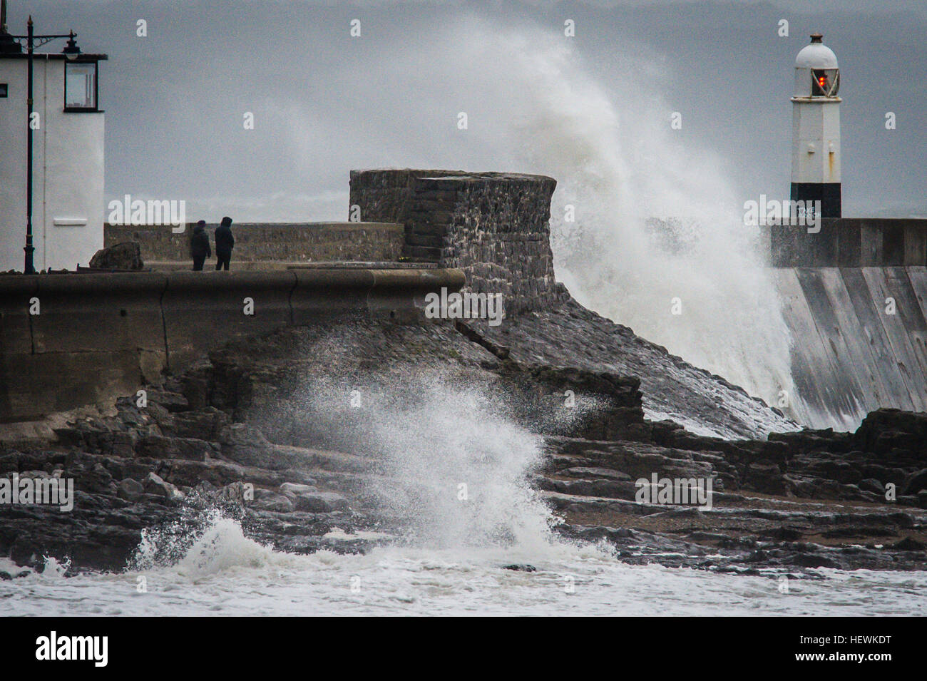 Die Menschen sehen Wellen über die Hafenmauer in Porthcawl, South Wales, wie Großbritannien und Irland auf die Ankunft des Sturms Barbara, mit Windgeschwindigkeiten von 90 km/h erwartet, dass einige Teile des Landes Teig verspannt sind. Stockfoto