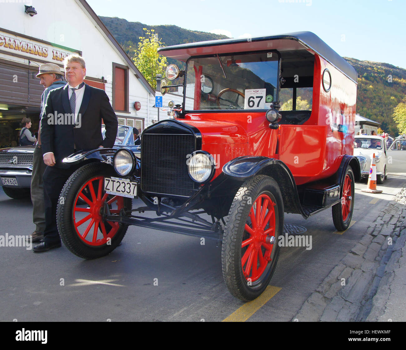 Dieses Foto vom Herbstfest in Arrowtown zeigt eine Oldtimershow mit restaurierten Oldtimern, darunter einem roten Ford-Van. Die Autoparade zeigt die reiche Geschichte der Automobilkultur in dieser malerischen Stadt. Stockfoto