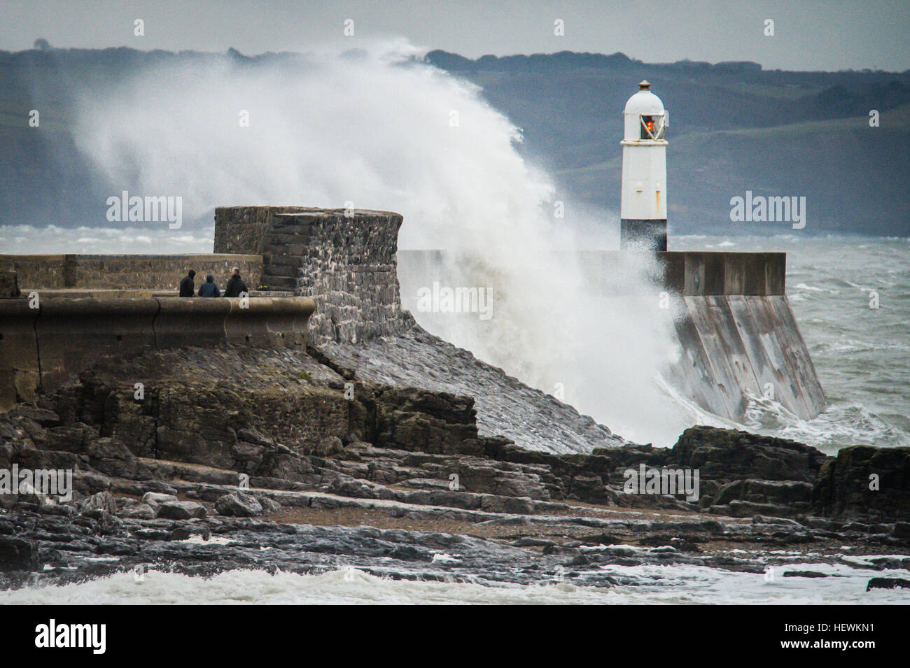 Die Menschen sehen Wellen über die Hafenmauer in Porthcawl, South Wales, wie Großbritannien und Irland auf die Ankunft des Sturms Barbara, mit Windgeschwindigkeiten von 90 km/h erwartet, dass einige Teile des Landes Teig verspannt sind. Stockfoto