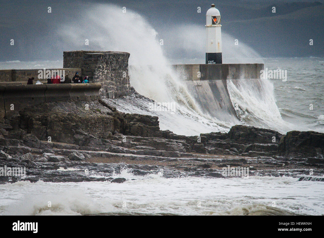 Die Menschen sehen Wellen über die Hafenmauer in Porthcawl, South Wales, wie Großbritannien und Irland auf die Ankunft des Sturms Barbara, mit Windgeschwindigkeiten von 90 km/h erwartet, dass einige Teile des Landes Teig verspannt sind. Stockfoto