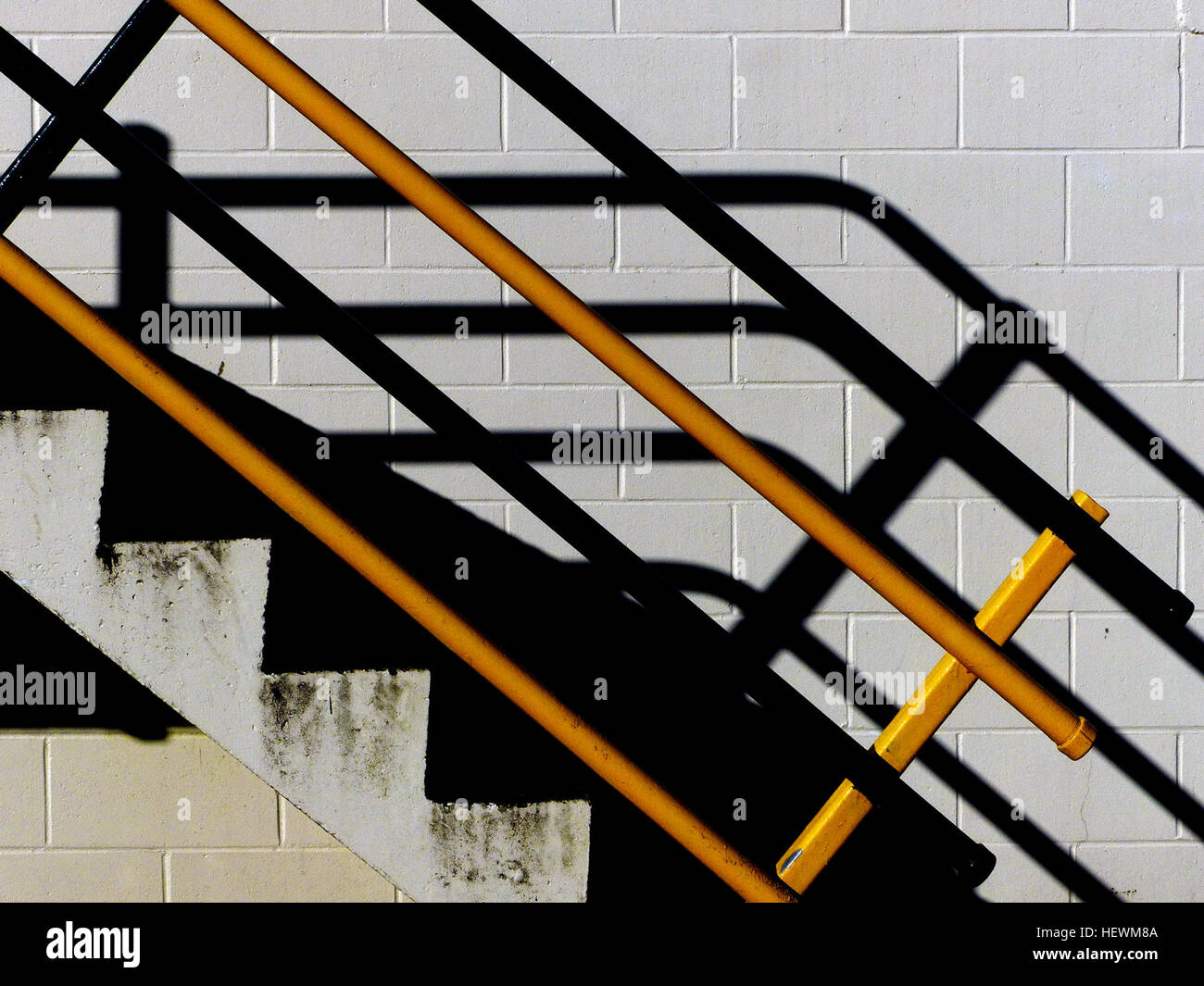 Dieses abstrakte Foto zeigt auffällige Kontraste von Schwarz und Gelb, die Flora mit starken Schatten einfangen. Das Bild wurde mit einem Panasonic DMC-FZ200 aufgenommen und betont Texturen, Lichtkontraste und die Einfachheit von Treppen und Stufen, die Natur und urbane Elemente miteinander verbinden. Stockfoto