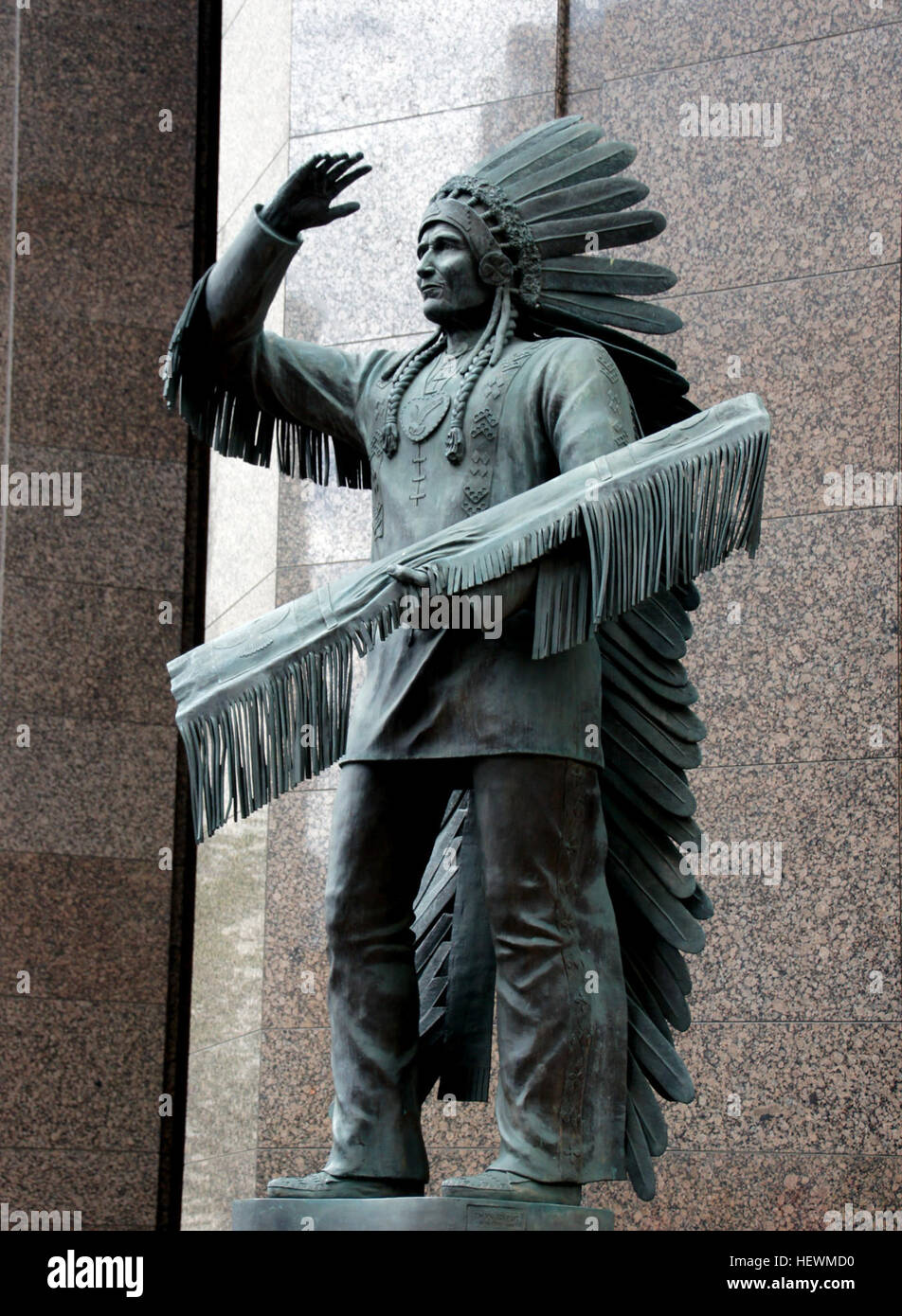 Eine Bronzestatue von Sitting Eagle, auch bekannt als John Hunter, in der Innenstadt von Calgary, Alberta, die indigene Kunst und kulturelles Erbe repräsentiert und die Beiträge indigener Führer zur kanadischen Geschichte würdigt. Stockfoto