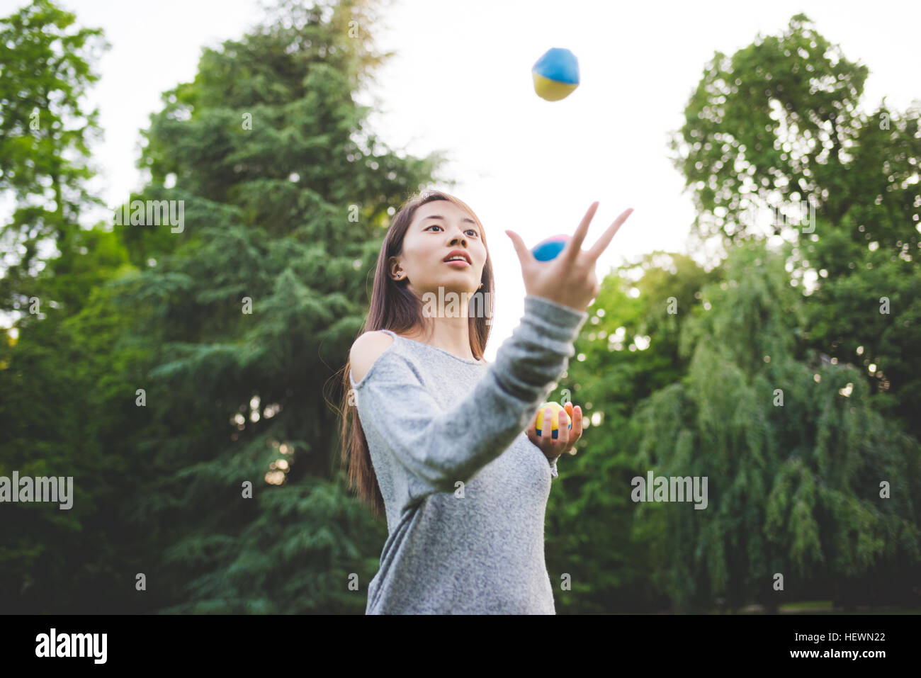 Junge Frau im Park Jonglierbälle Stockfoto